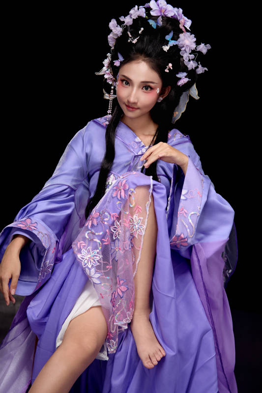 身著簪花仕女裝扮坐在木桌上的東方女性