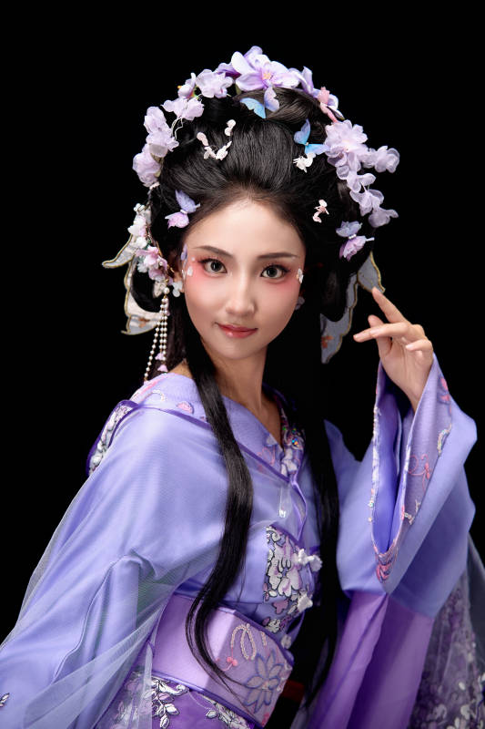 身着簪花仕女装扮坐在木桌上的东方女性