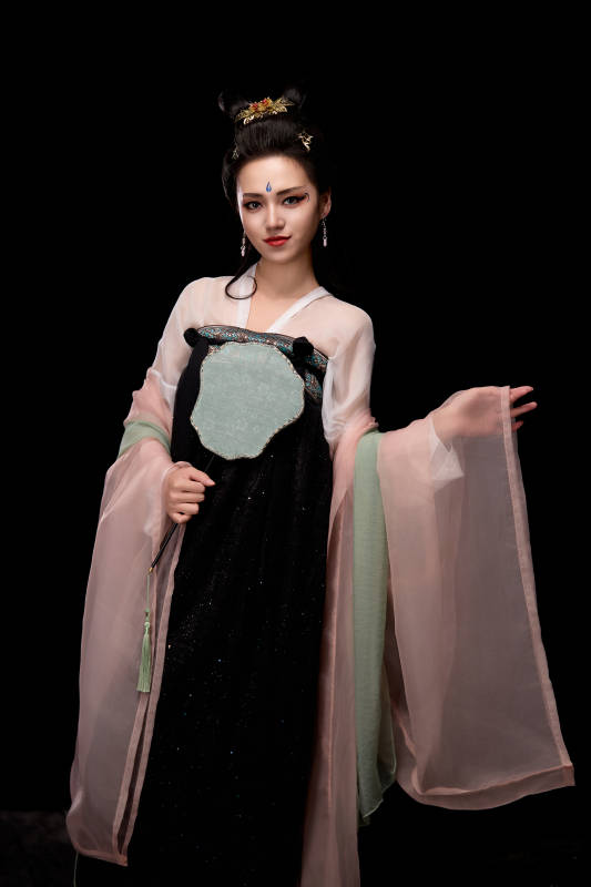 手持轻扇展示唐代服饰妆容造型的东方女性