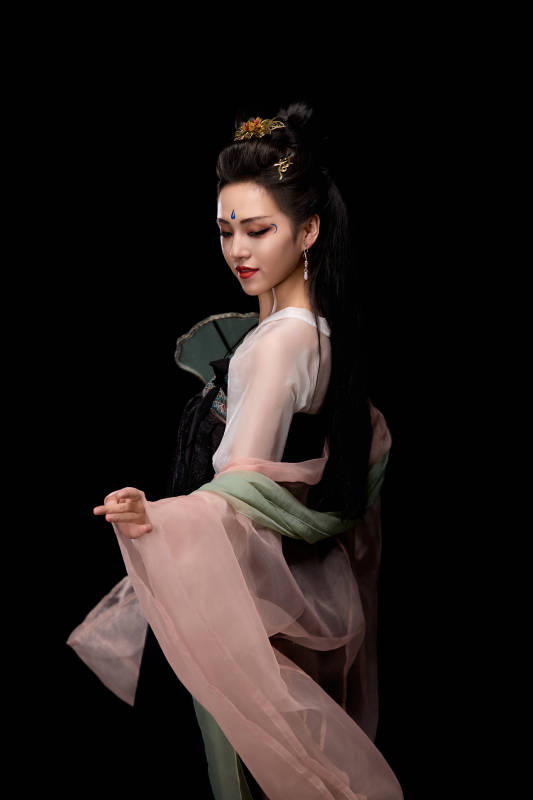 手持轻扇展示唐代服饰妆容造型的东方女性