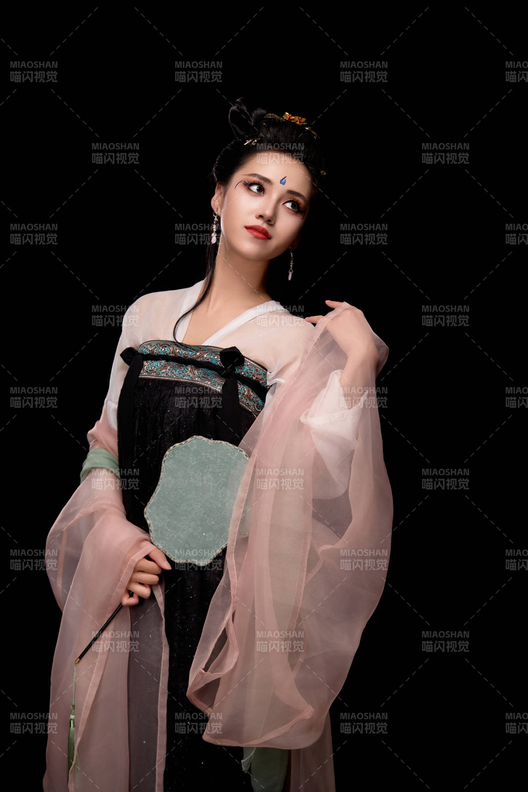 手持轻扇展示唐代服饰妆容造型的东方女性