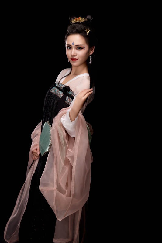 手持轻扇展示唐代服饰妆容造型的东方女性