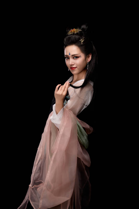 手持轻扇展示唐代服饰妆容造型的东方女性