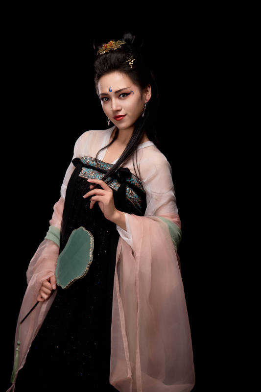 手持轻扇展示唐代服饰妆容造型的东方女性