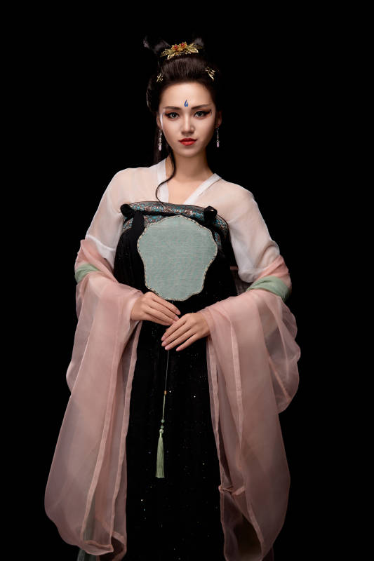 手持轻扇展示唐代服饰妆容造型的东方女性