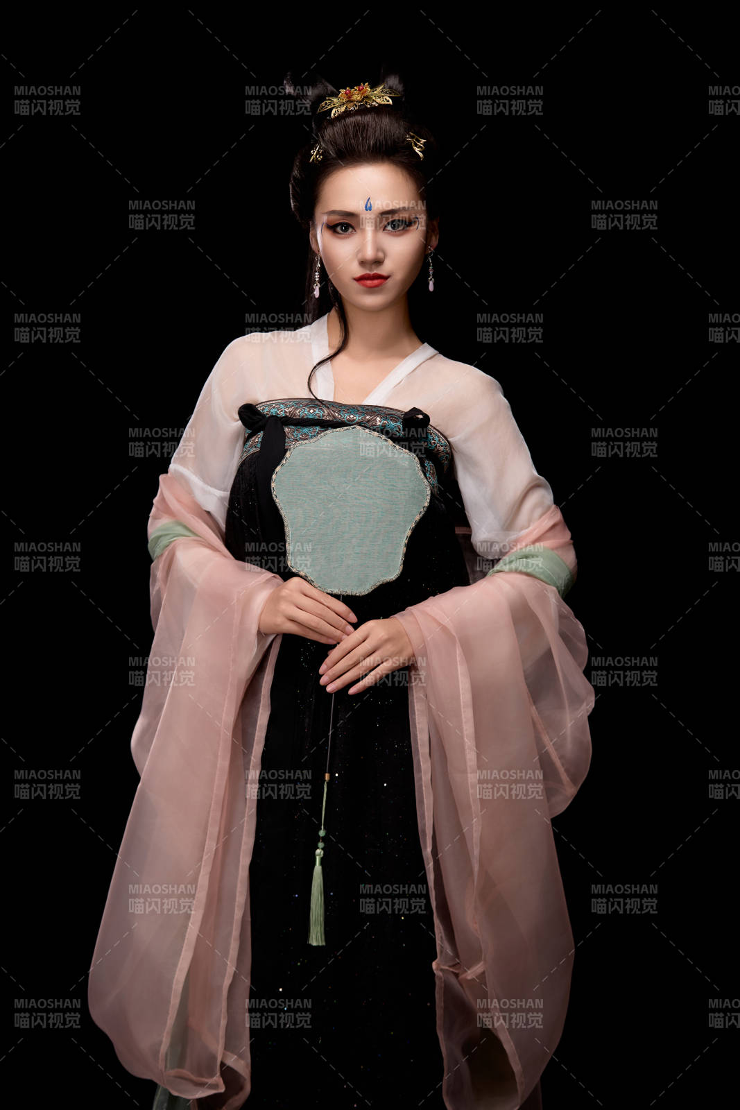 手持轻扇展示唐代服饰妆容造型的东方女性