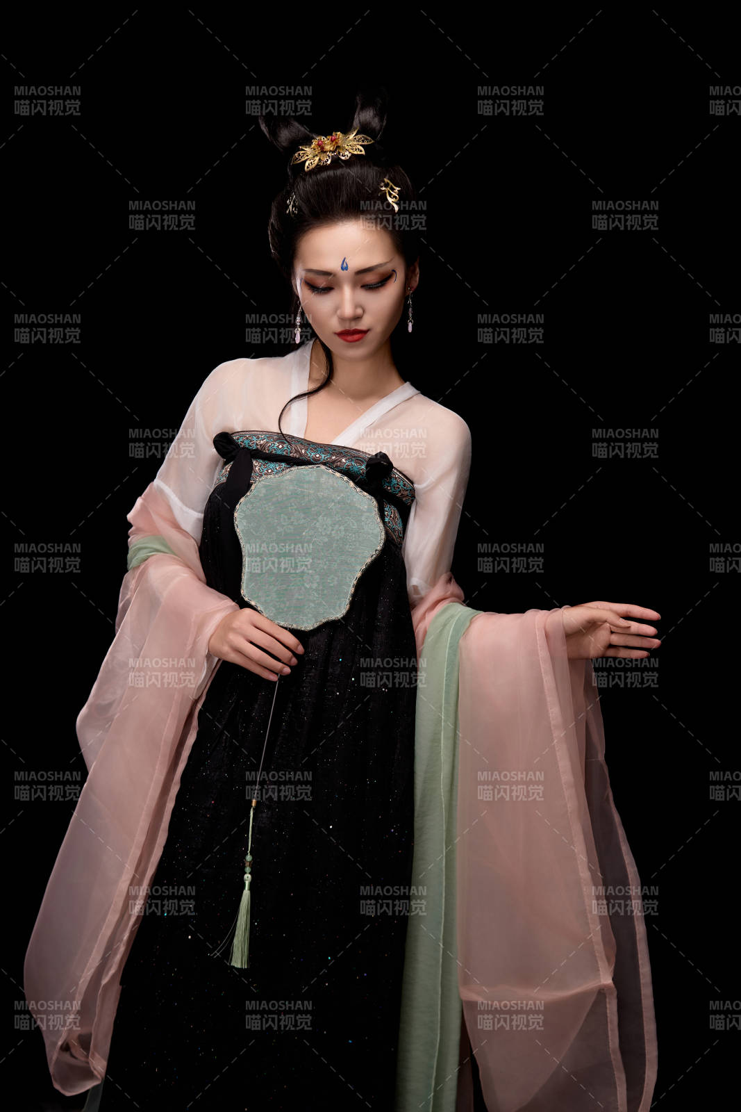 手持輕扇展示唐代服飾妝容造型的東方女性