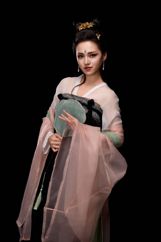 手持轻扇展示唐代服饰妆容造型的东方女性