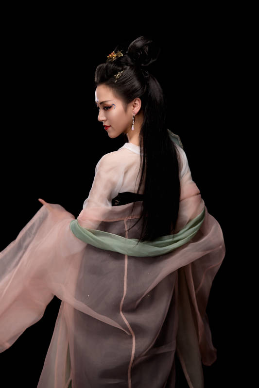 手持轻扇展示唐代服饰妆容造型的东方女性