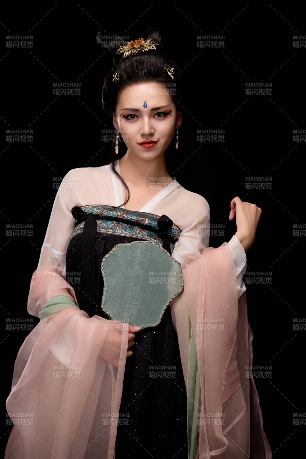 手持輕扇展示唐代服飾妝容造型的東方女性