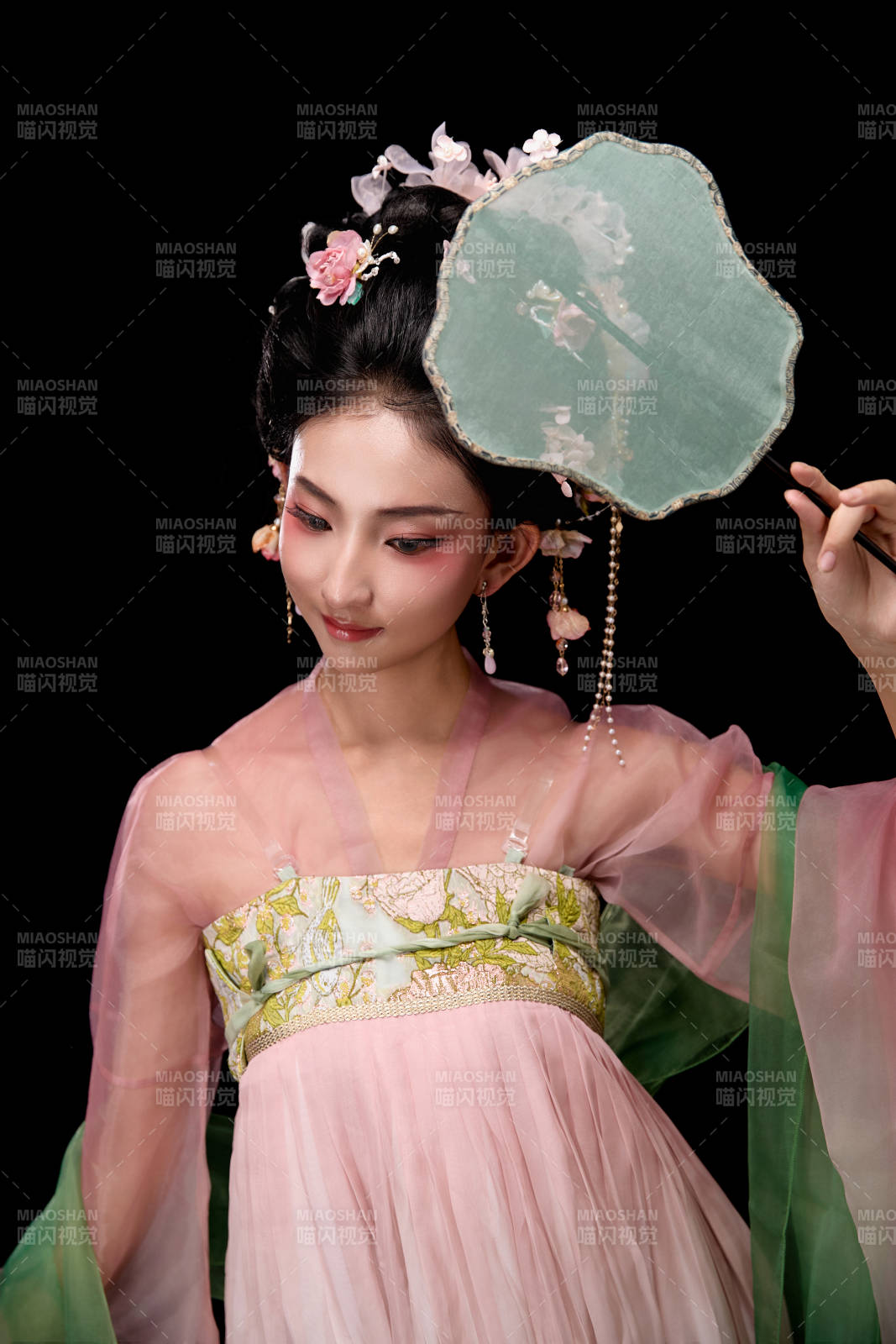 身着唐代宫廷簪花仕女服手持轻扇的女性