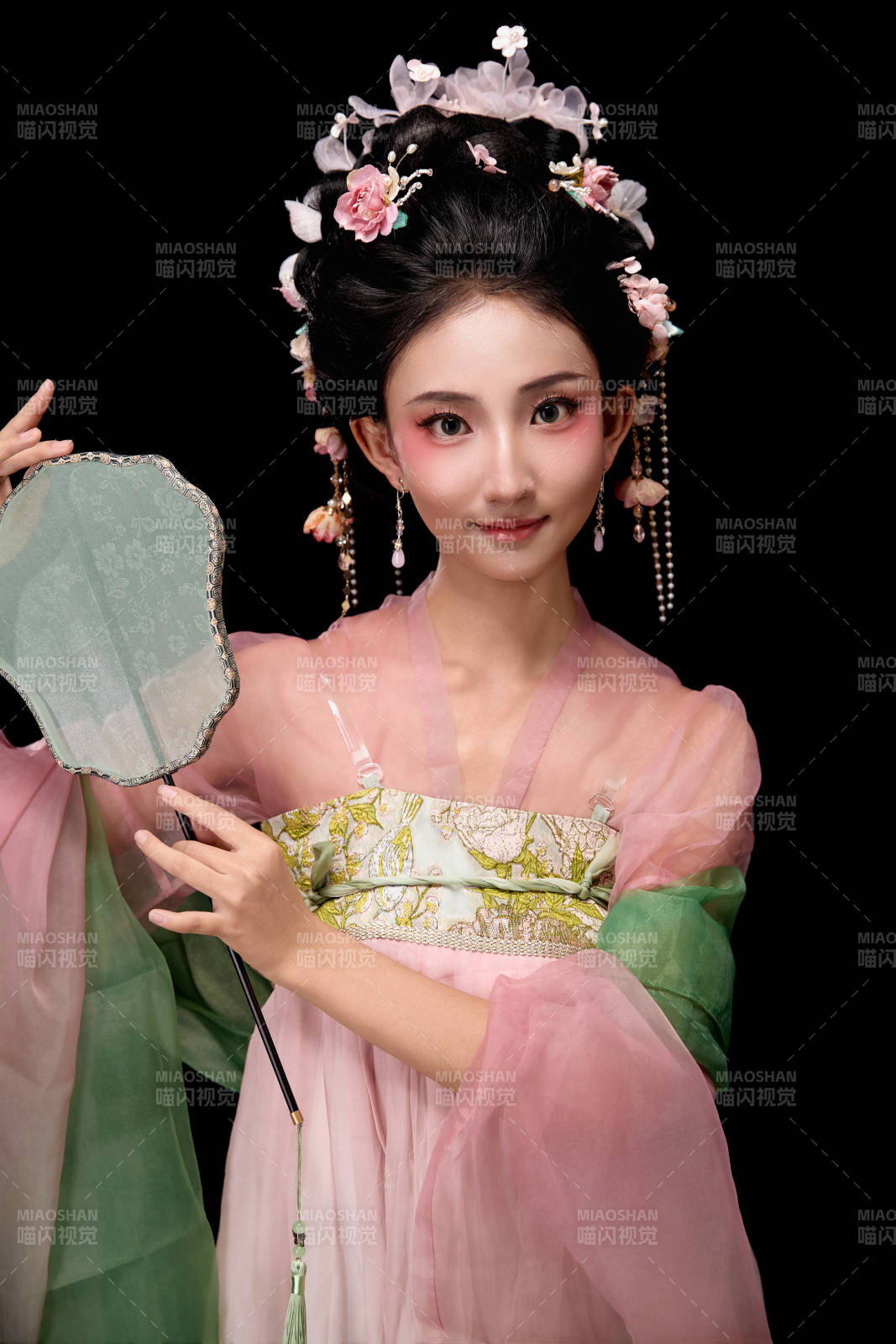 身著唐代宮廷簪花仕女服手持輕扇的女性