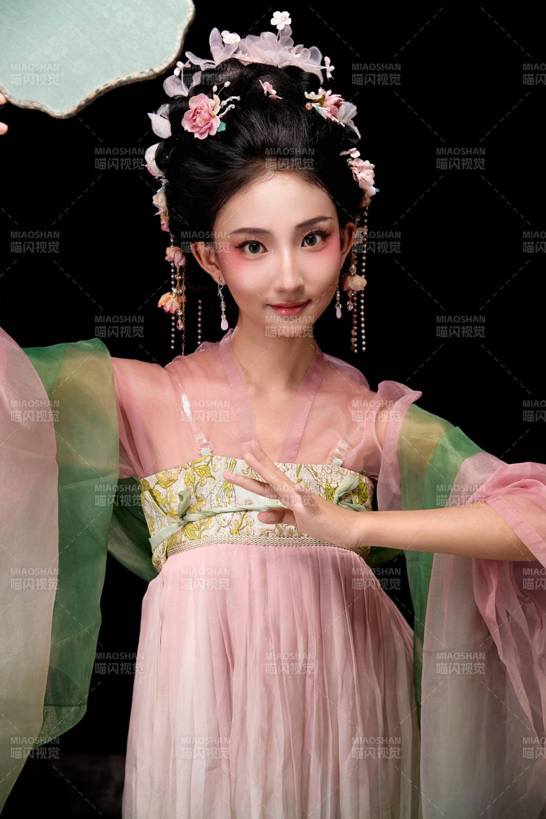 身著唐代宮廷簪花仕女服手持輕扇的女性