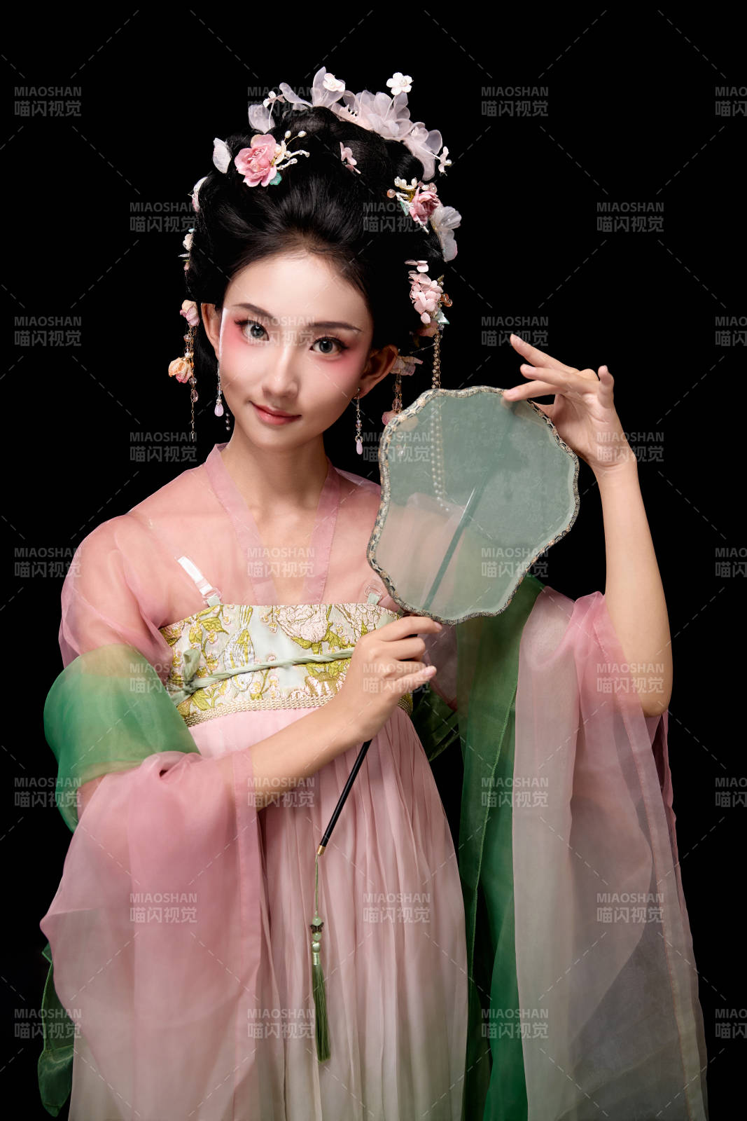 身著唐代宮廷簪花仕女服手持輕扇的女性