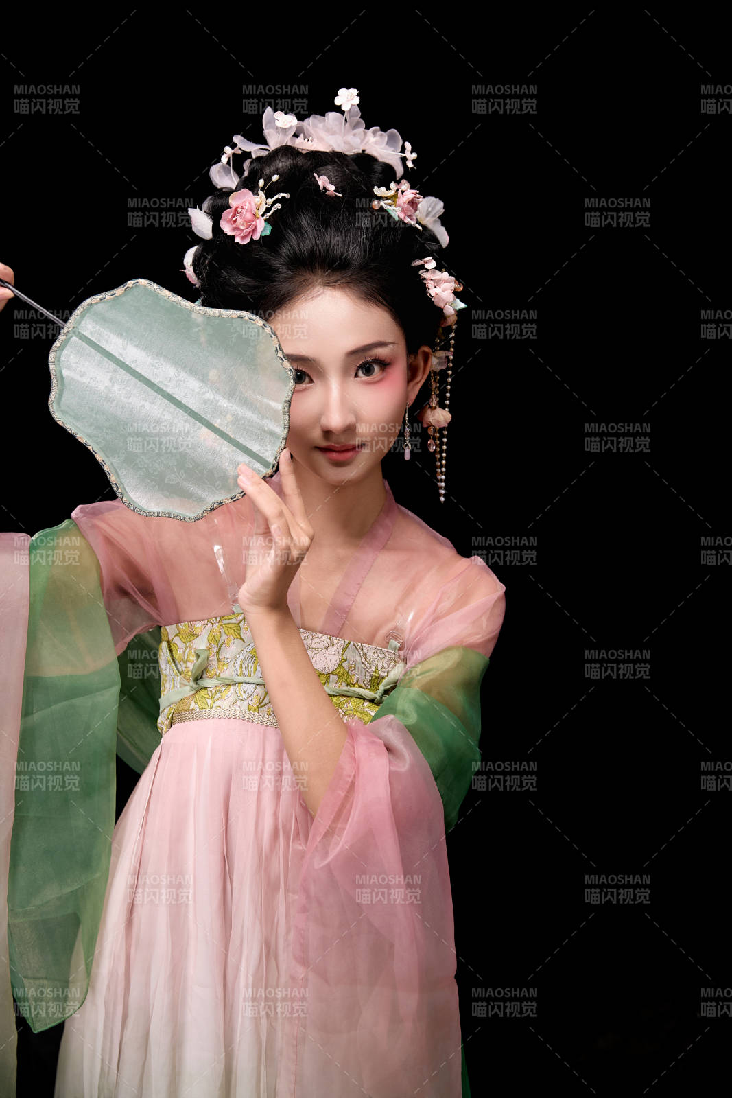 身著唐代宮廷簪花仕女服手持輕扇的女性