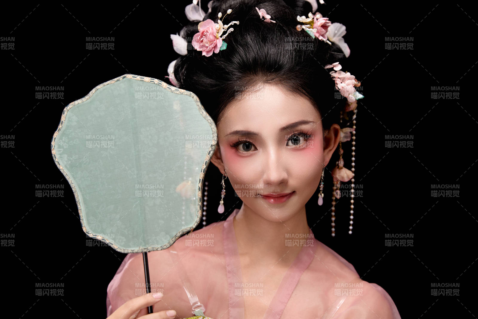 身著唐代宮廷簪花仕女服手持輕扇的女性