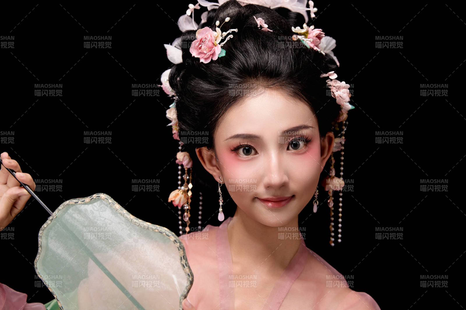 身著唐代宮廷簪花仕女服手持輕扇的女性