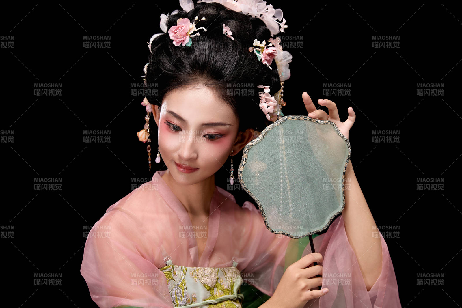 身著唐代宮廷簪花仕女服手持輕扇的女性