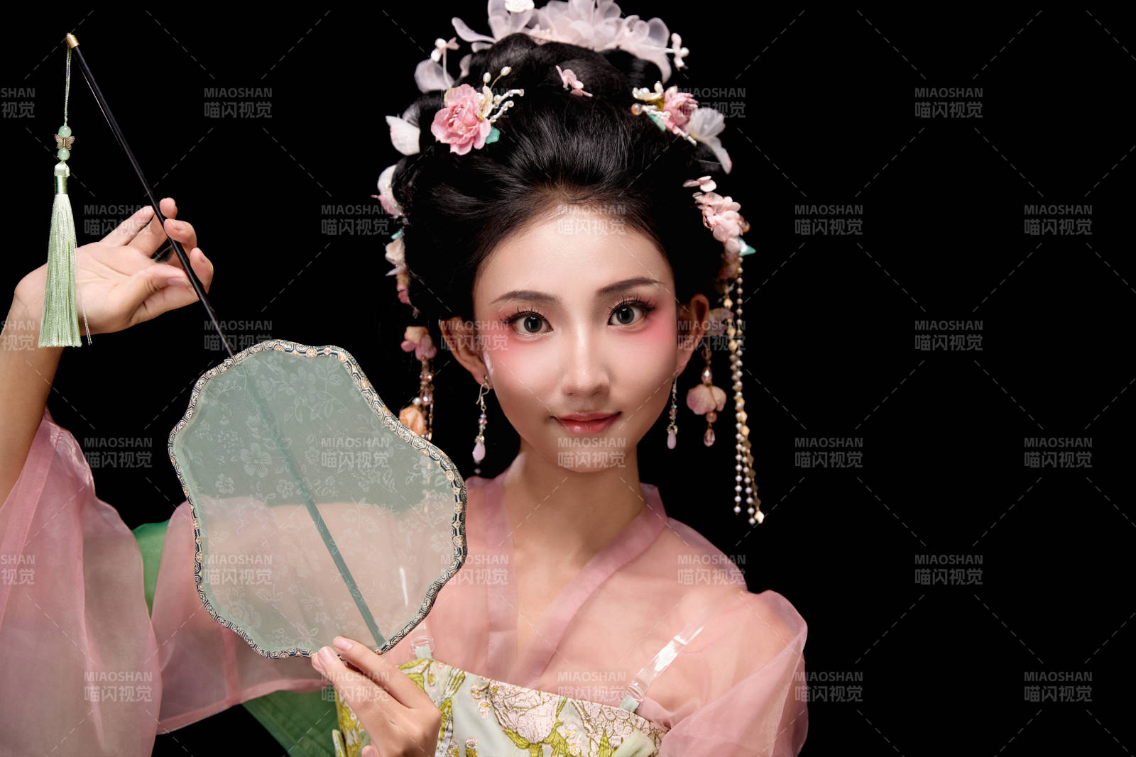 身著唐代宮廷簪花仕女服手持輕扇的女性