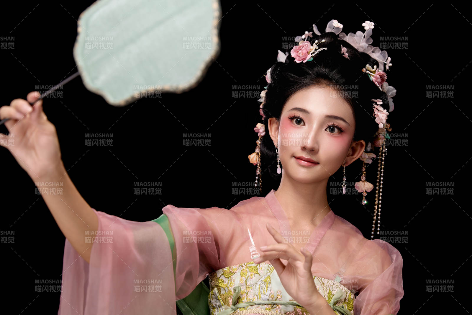 身著唐代宮廷簪花仕女服手持輕扇的女性