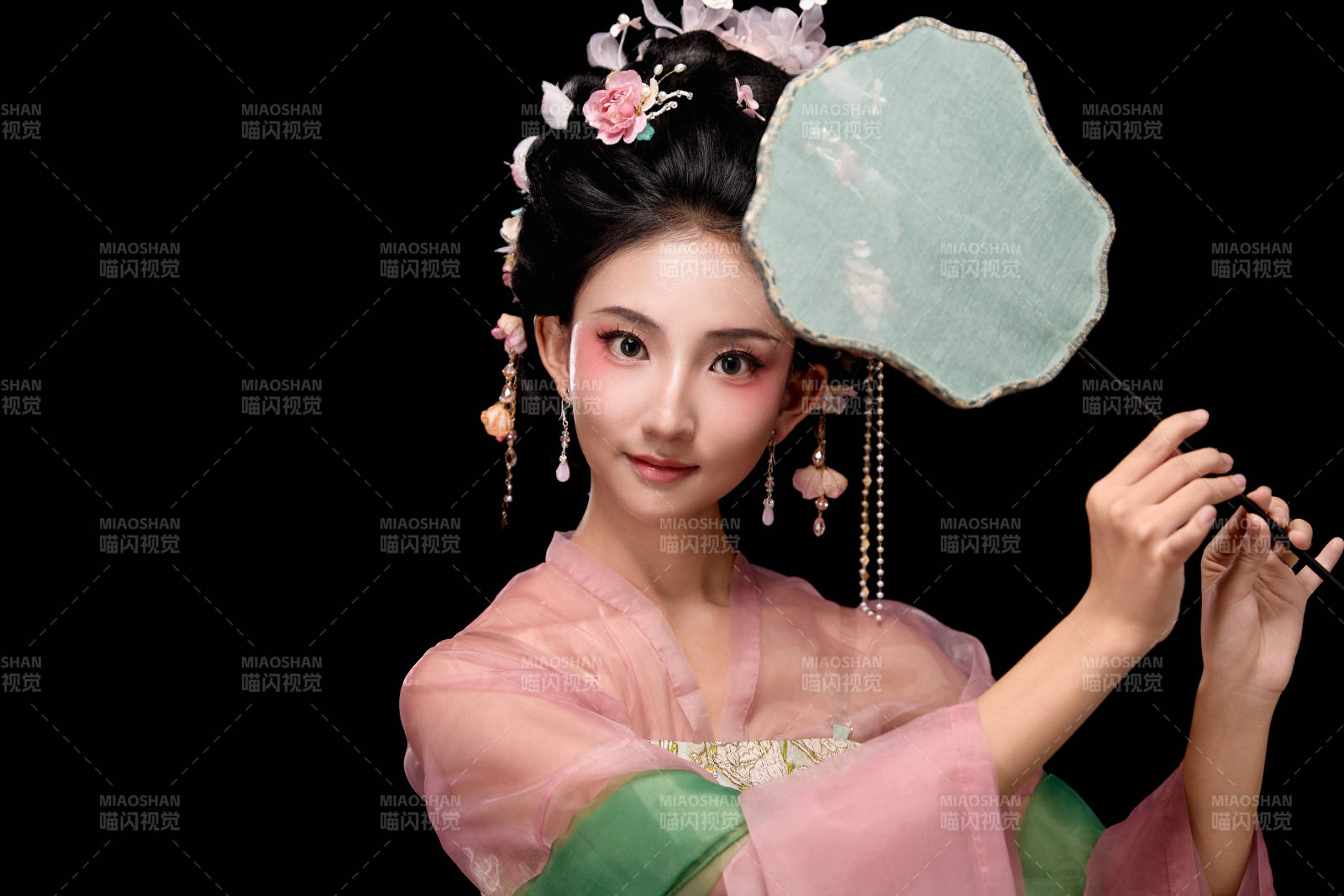 身著唐代宮廷簪花仕女服手持輕扇的女性