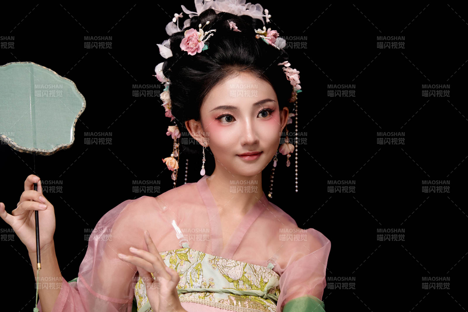 身著唐代宮廷簪花仕女服手持輕扇的女性