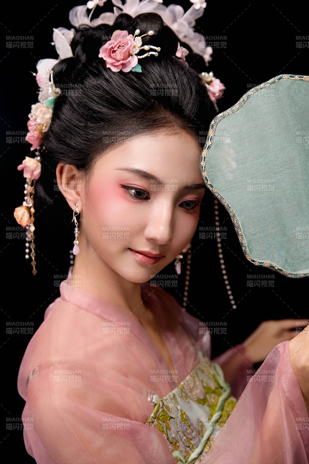 身著唐代宮廷簪花仕女服手持輕扇的女性