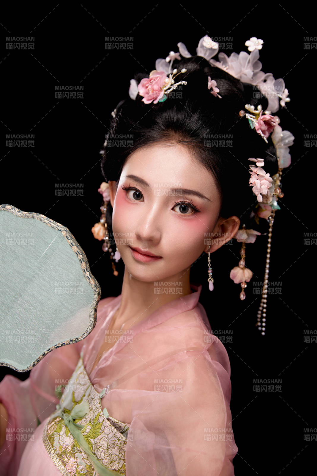 身著唐代宮廷簪花仕女服手持輕扇的女性