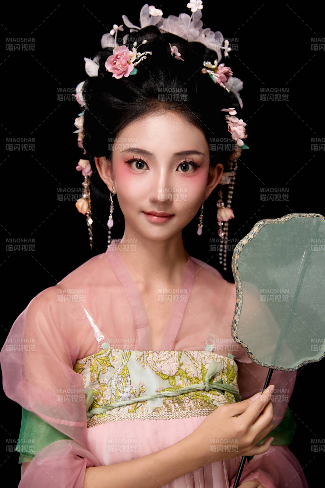 身著唐代宮廷簪花仕女服手持輕扇的女性