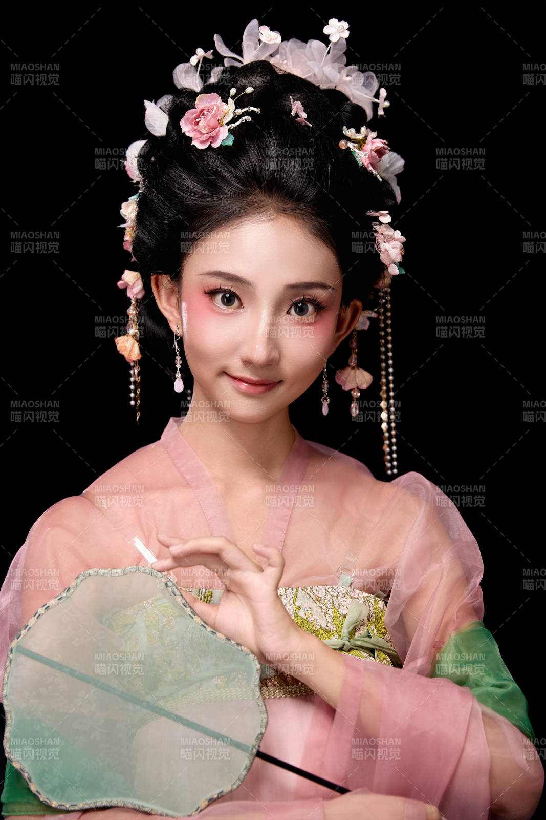 身著唐代宮廷簪花仕女服手持輕扇的女性