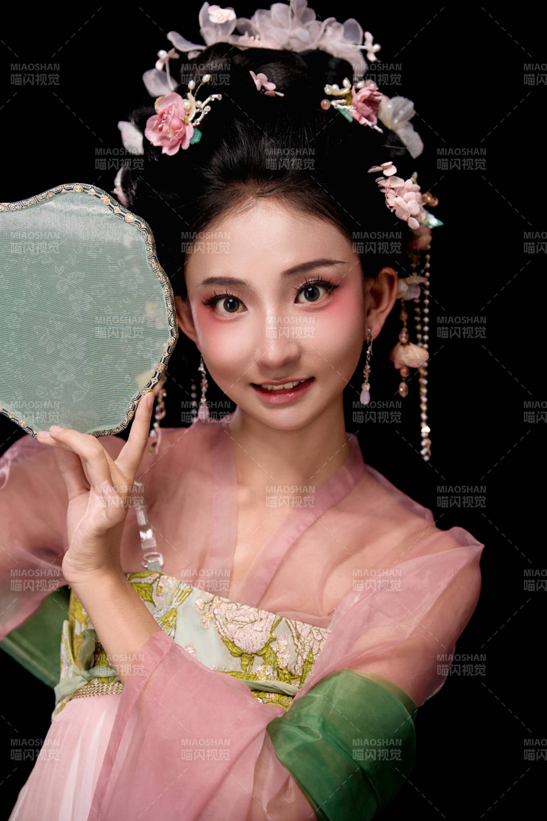 身著唐代宮廷簪花仕女服手持輕扇的女性