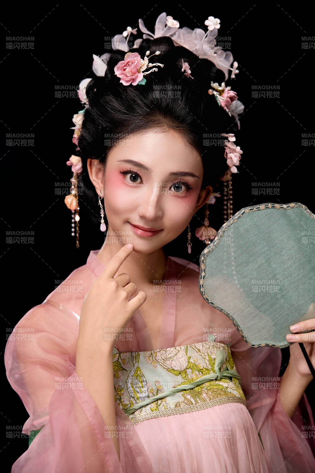 身著唐代宮廷簪花仕女服手持輕扇的女性