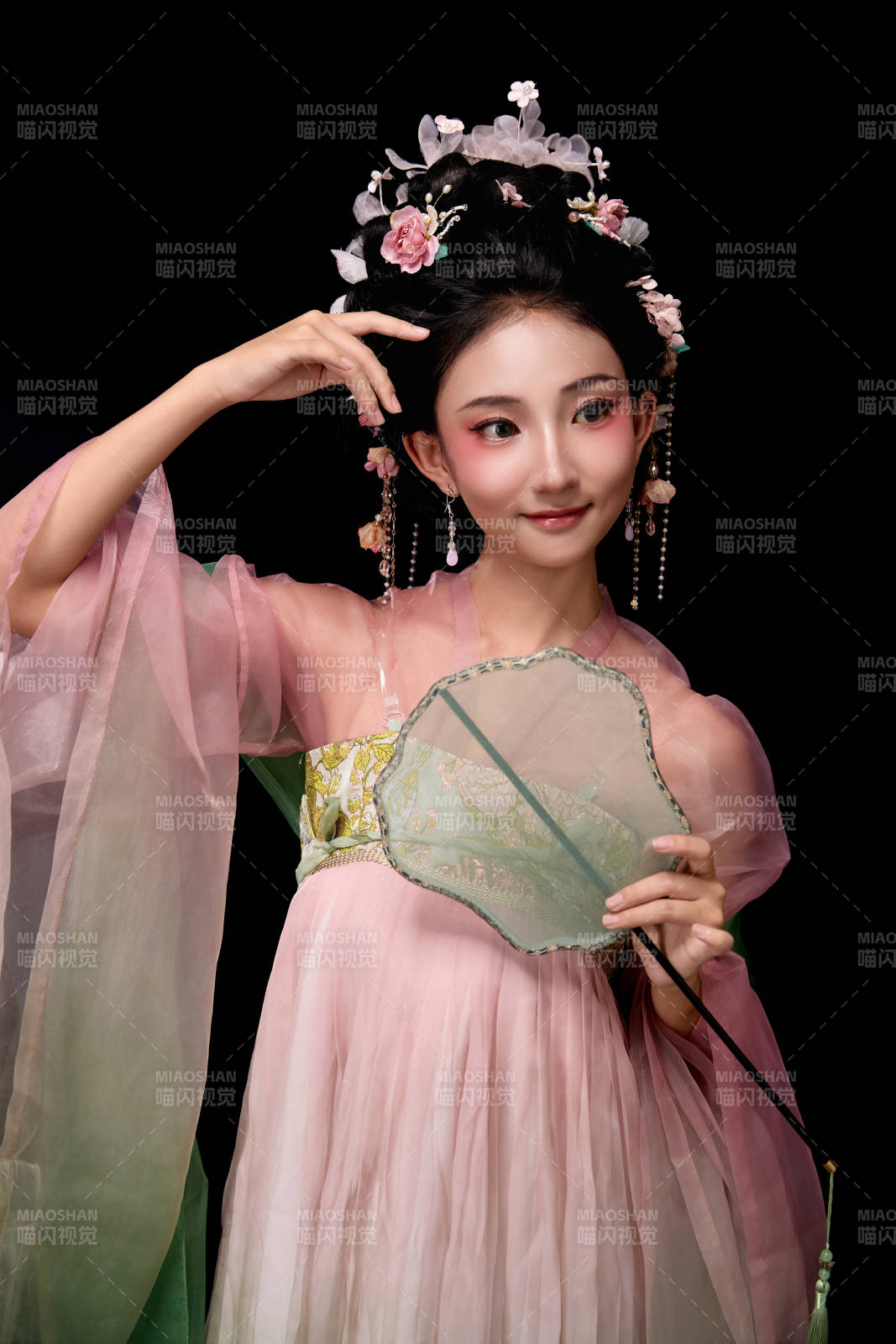 身著唐代宮廷簪花仕女服手持輕扇的女性