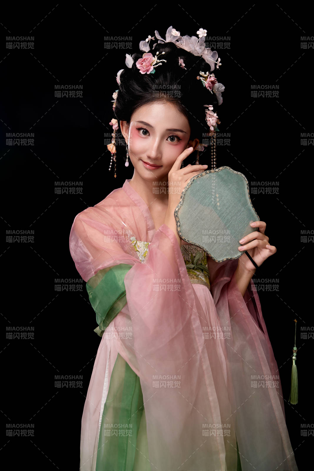 身著唐代宮廷簪花仕女服手持輕扇的女性