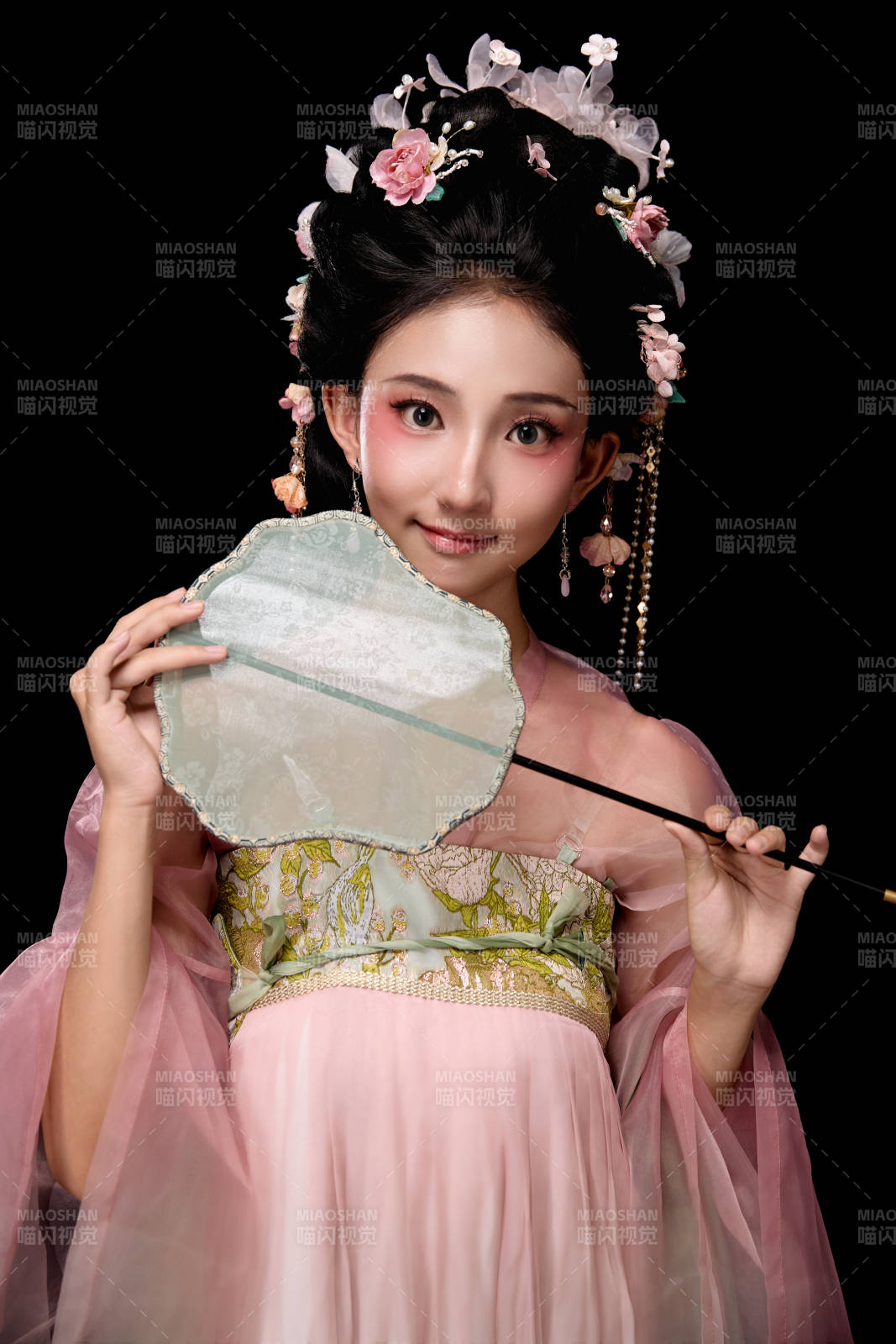 身著唐代宮廷簪花仕女服手持輕扇的女性