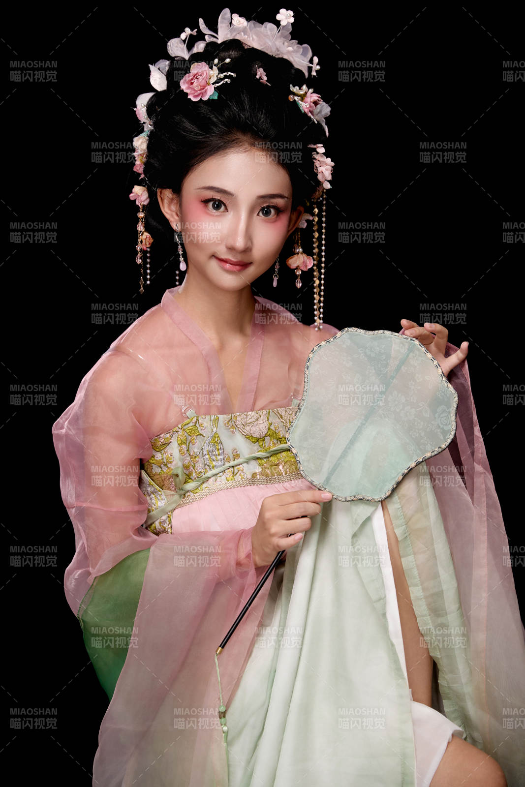 身著唐代簪花仕女服手持輕扇的坐姿女性