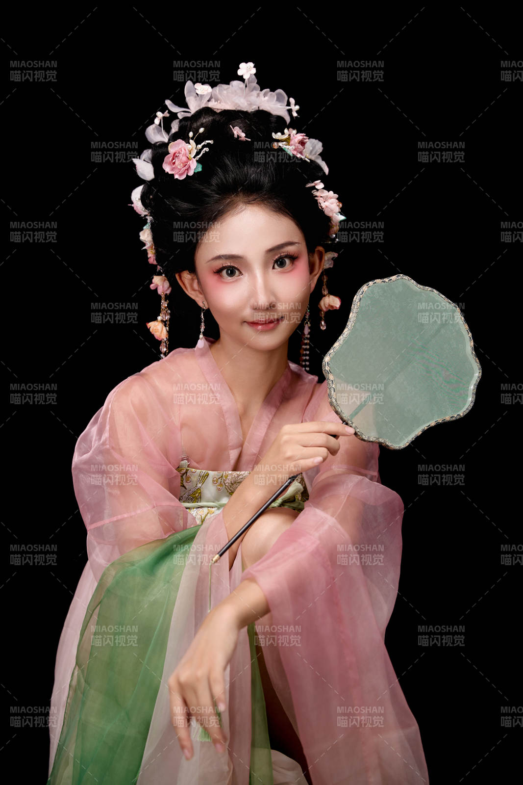 身著唐代簪花仕女服手持輕扇的坐姿女性