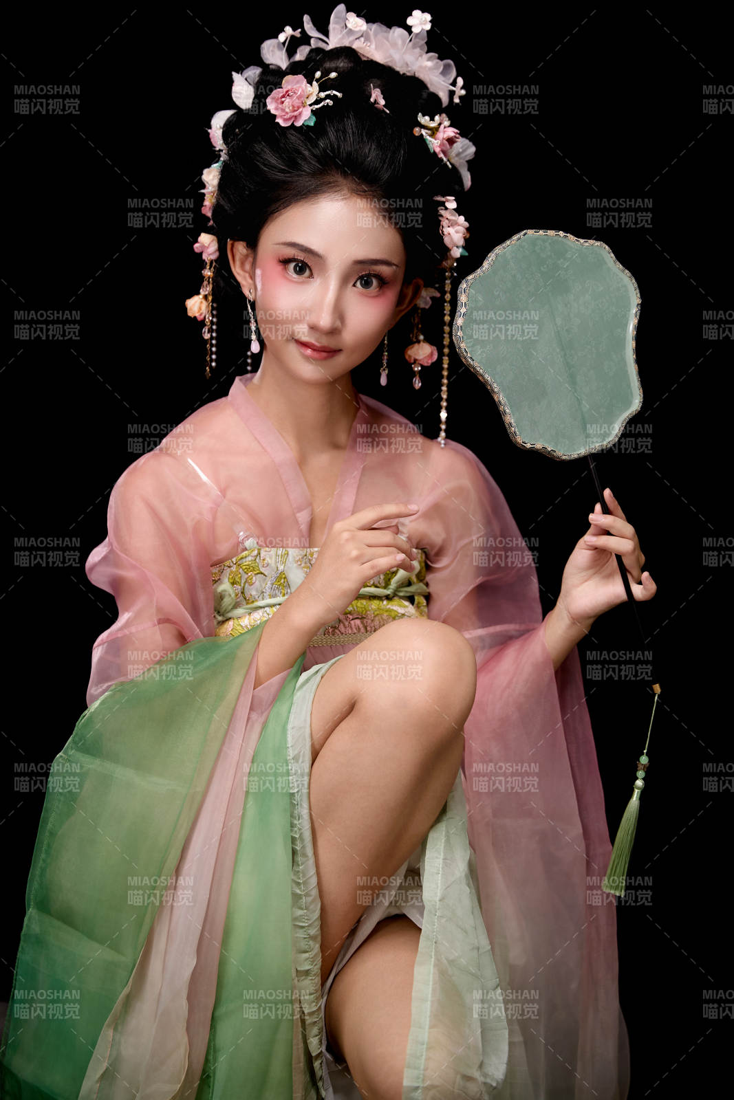 身著唐代簪花仕女服手持輕扇的坐姿女性