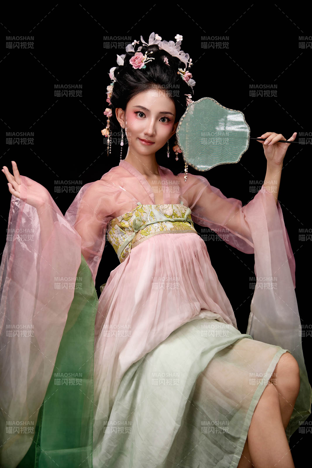 身著唐代簪花仕女服手持輕扇的坐姿女性