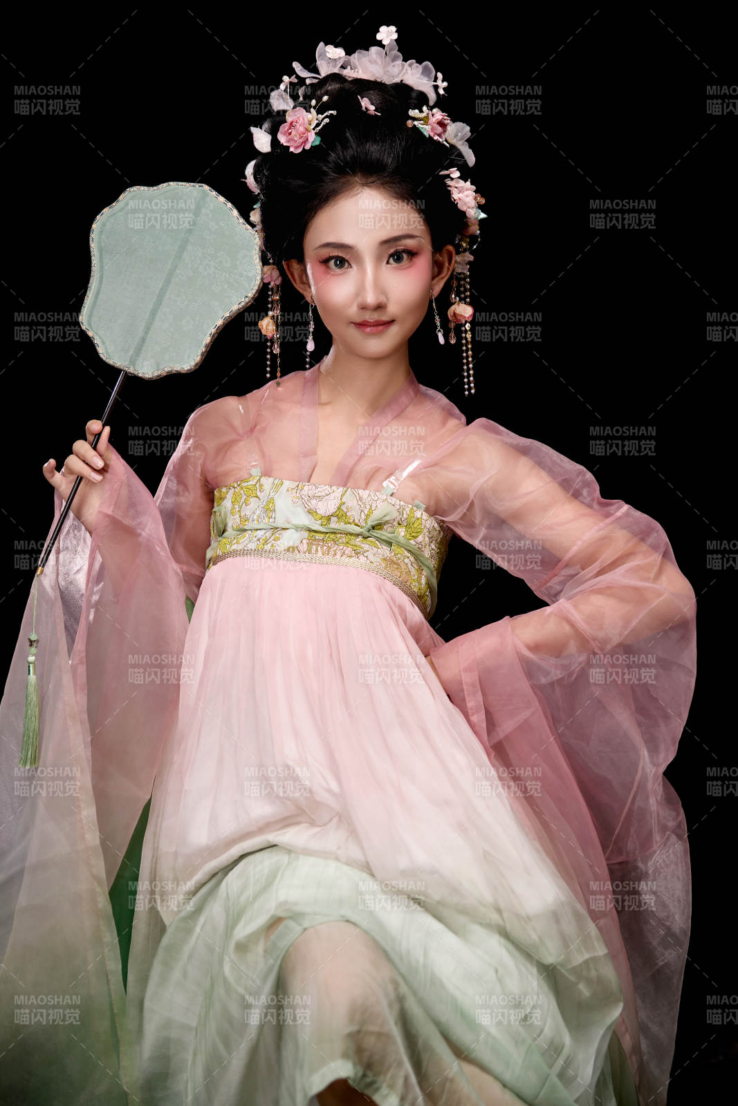 身著唐代簪花仕女服手持輕扇的坐姿女性