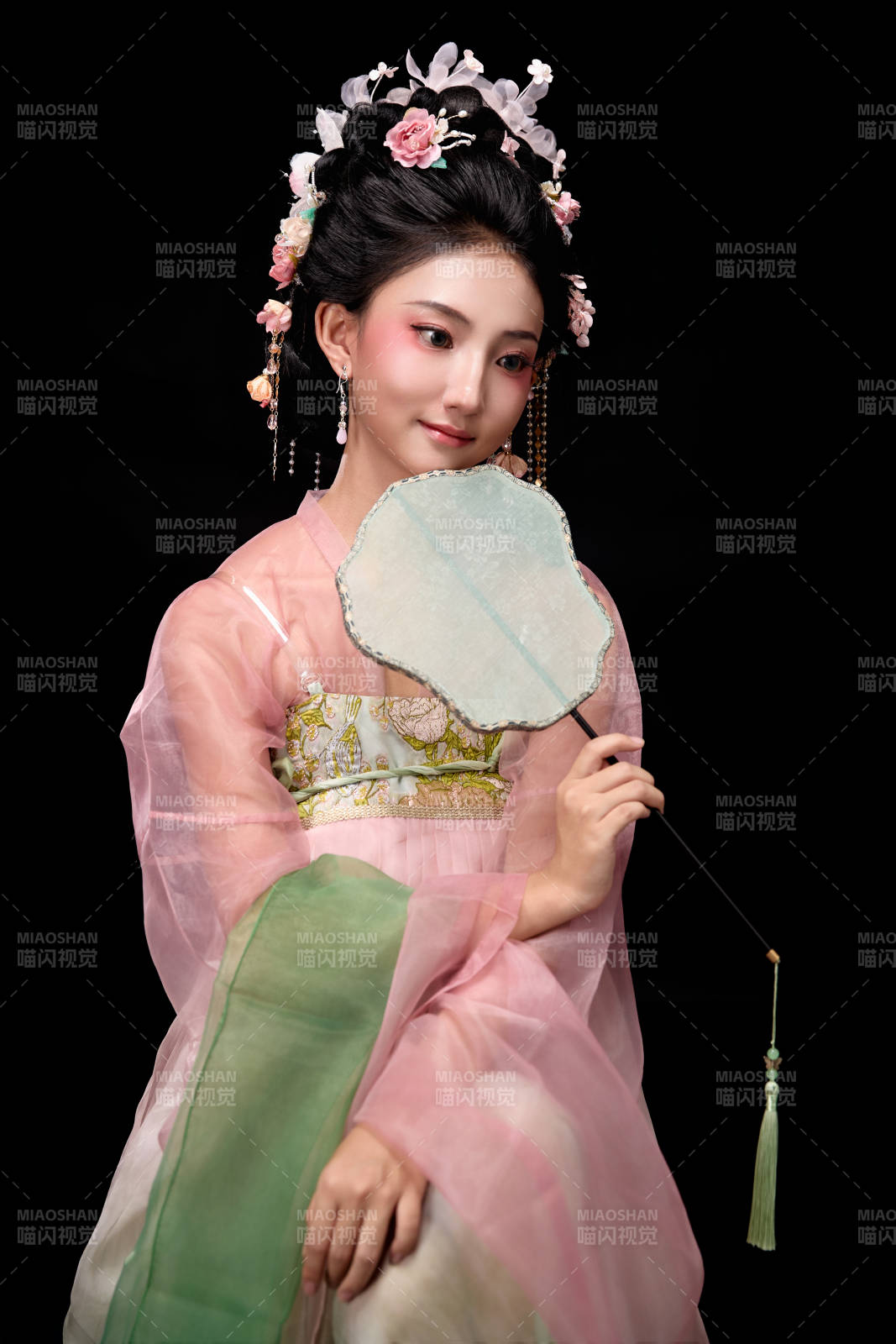 身著唐代簪花仕女服手持輕扇的坐姿女性