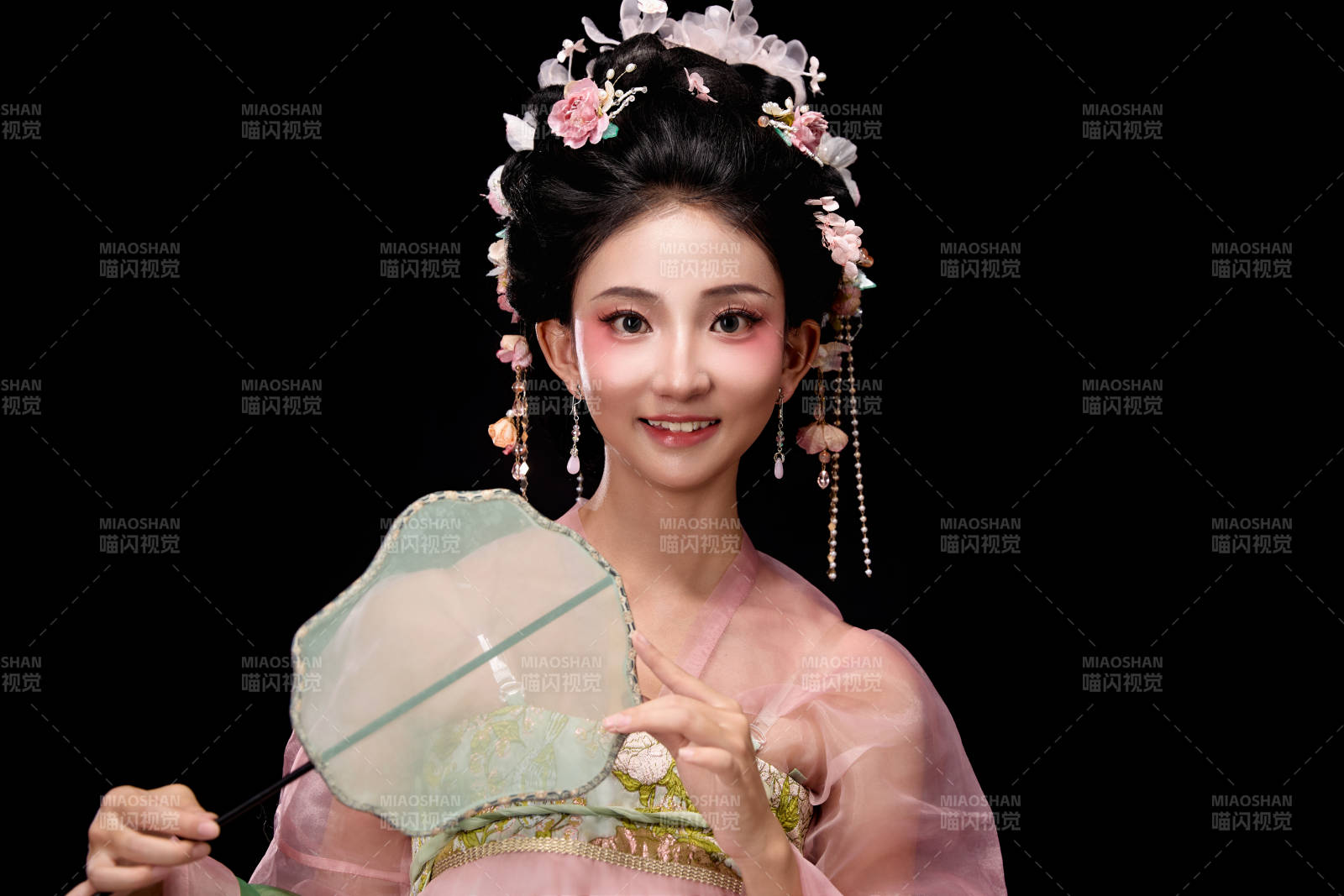 身著唐代簪花仕女服手持輕扇的坐姿女性