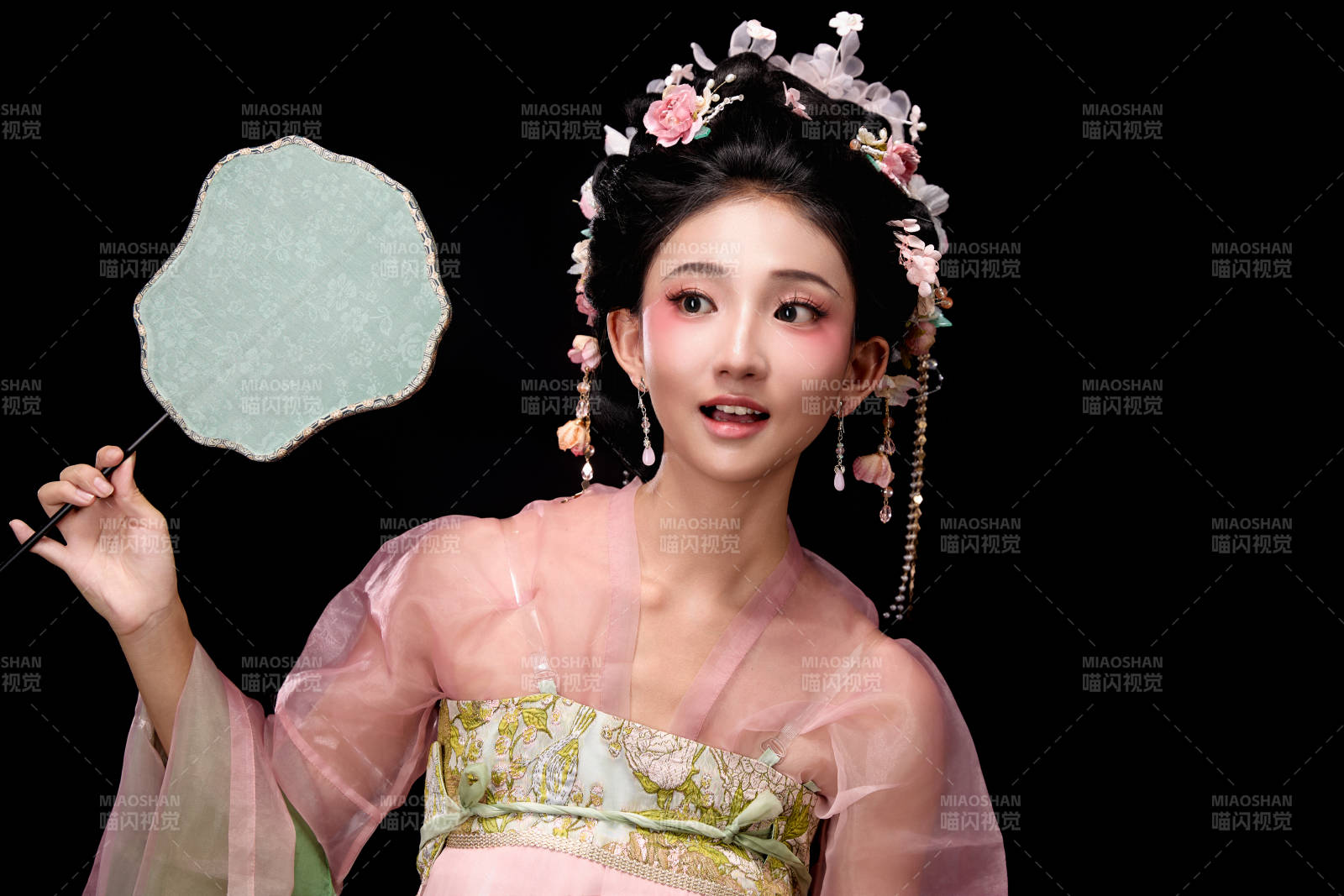 身著唐代簪花仕女服手持輕扇的坐姿女性