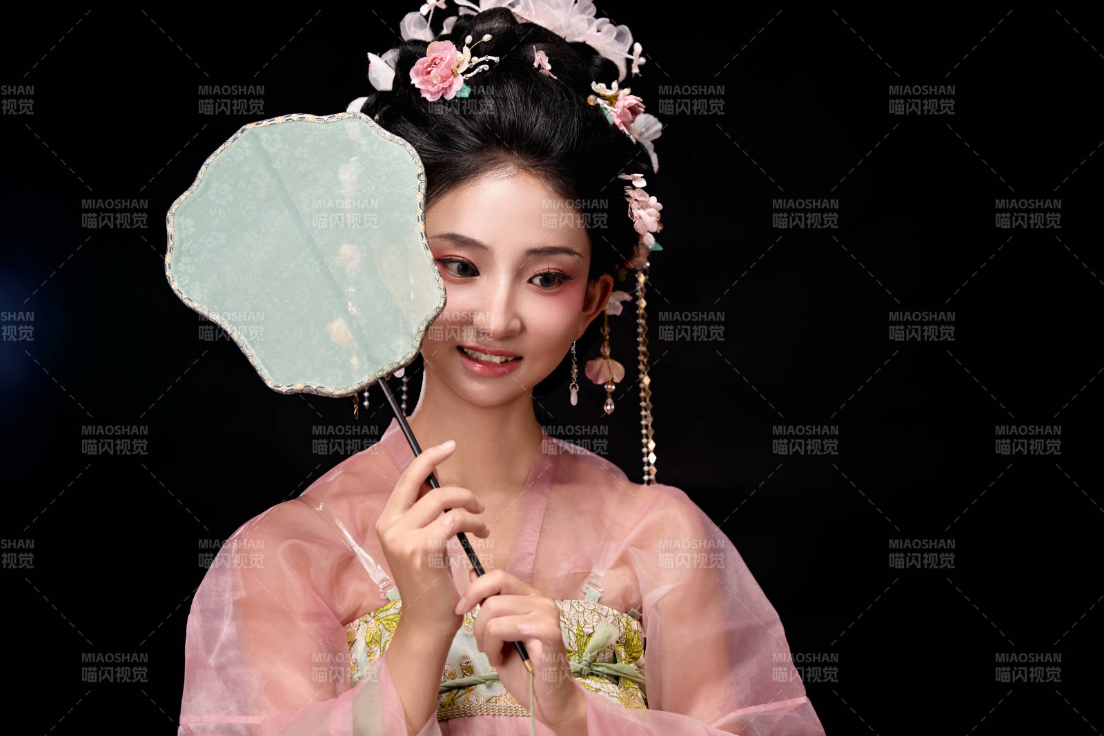 身著唐代簪花仕女服手持輕扇的坐姿女性