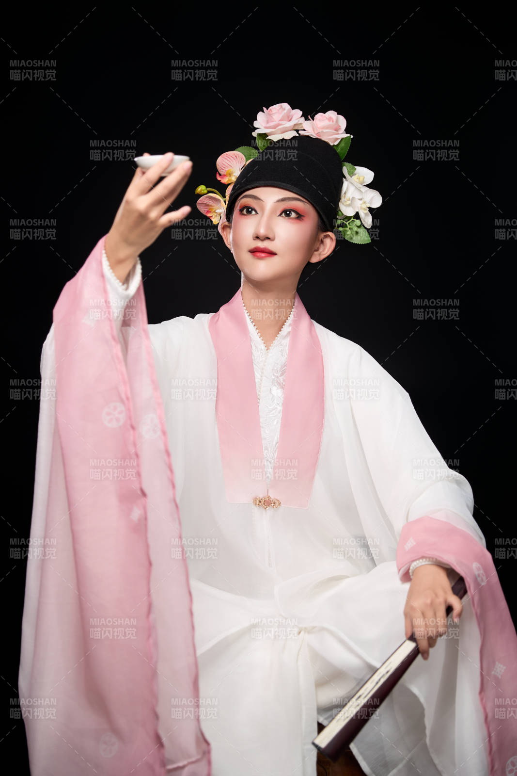 身著粵劇反串裝扮手持酒杯折扇的青年女性