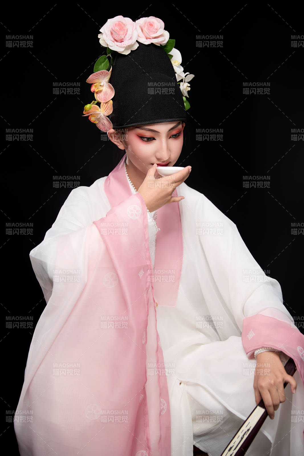 身著粵劇反串裝扮手持酒杯折扇的青年女性