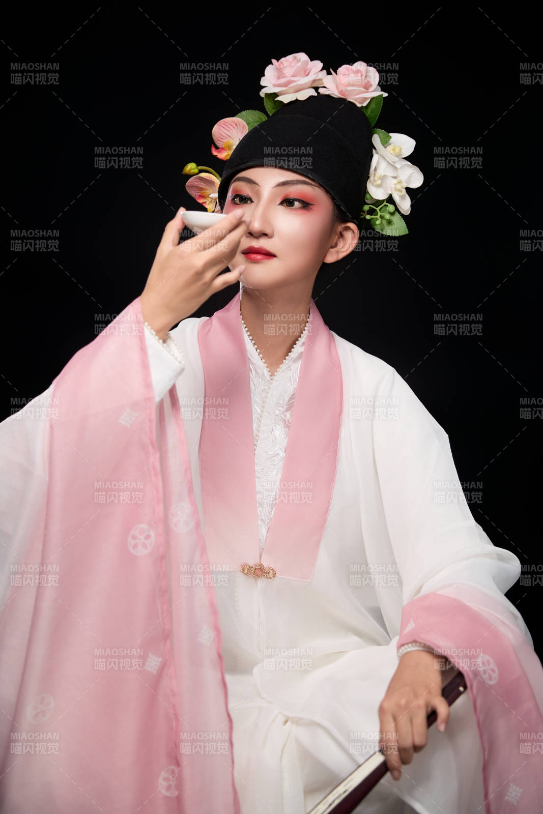 身著粵劇反串裝扮手持酒杯折扇的青年女性