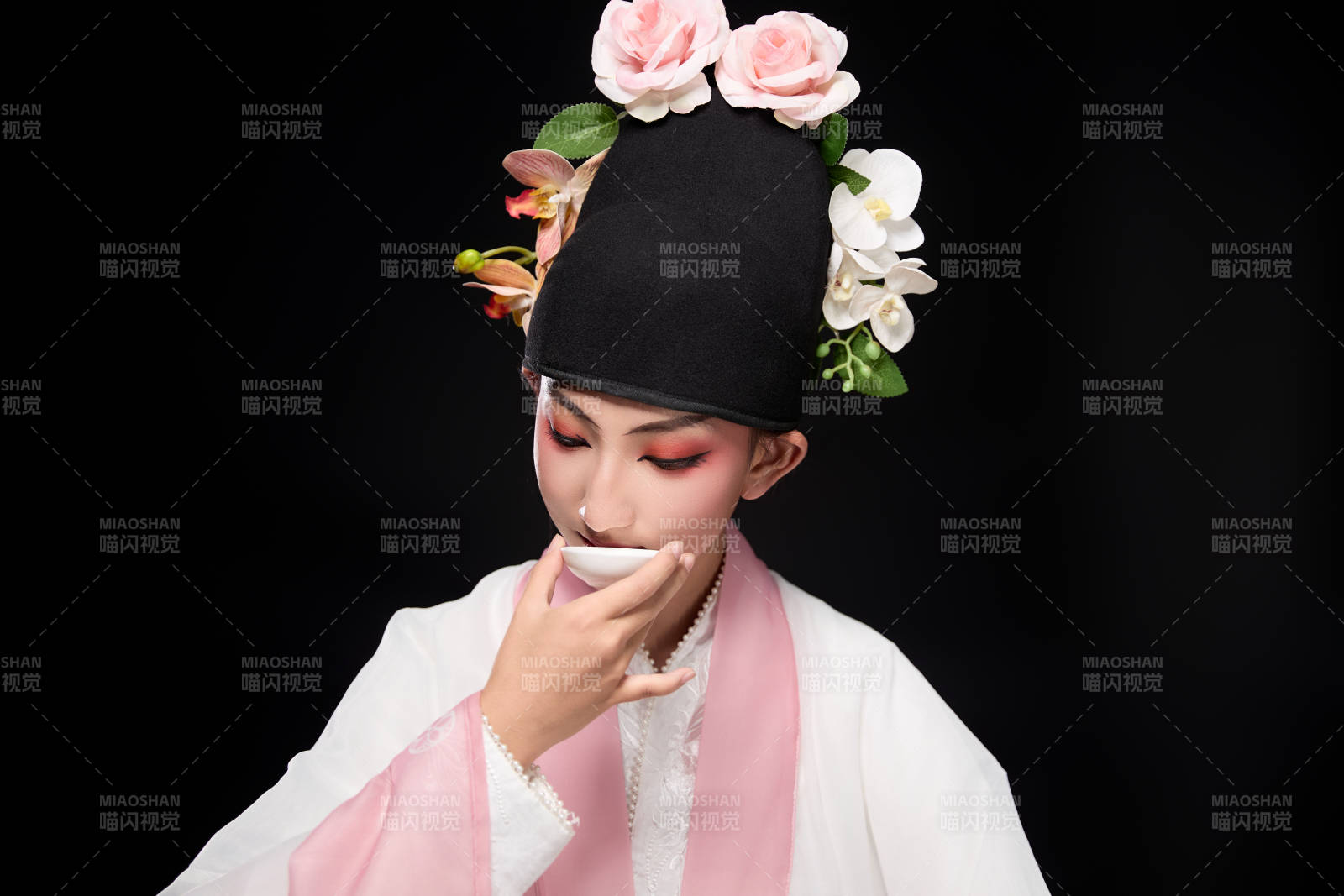 身著粵劇反串裝扮手持酒杯折扇的青年女性