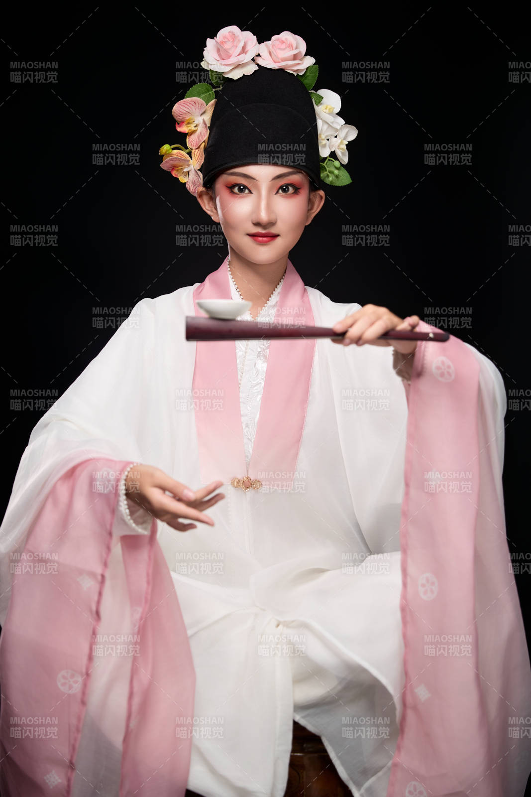 身著粵劇反串裝扮手持酒杯折扇的青年女性