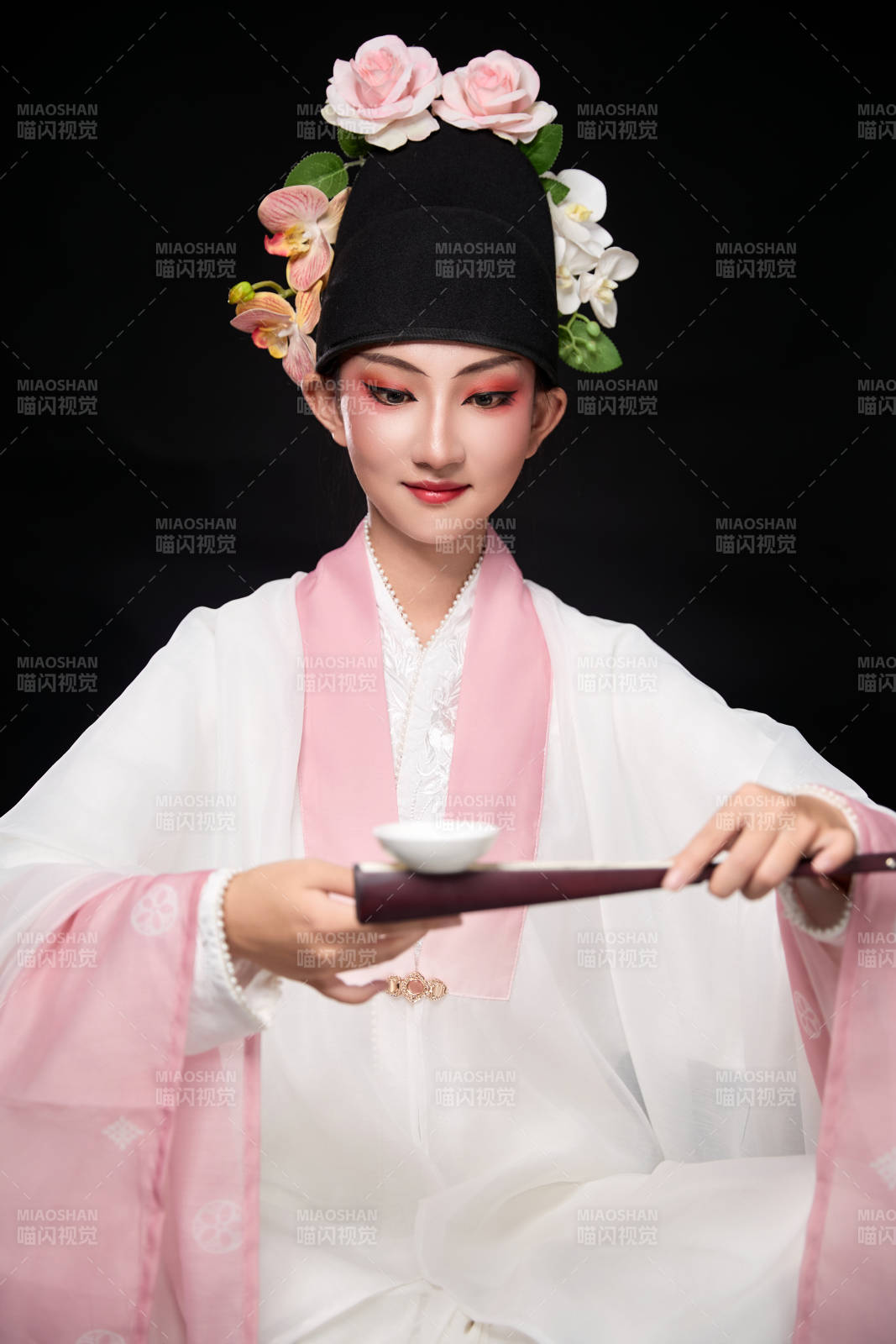身著粵劇反串裝扮手持酒杯折扇的青年女性